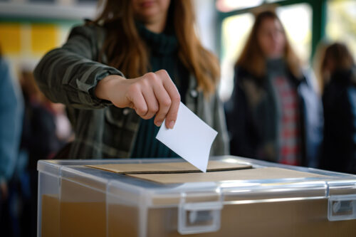 Žena ubacuje listić u glasačku kutiju